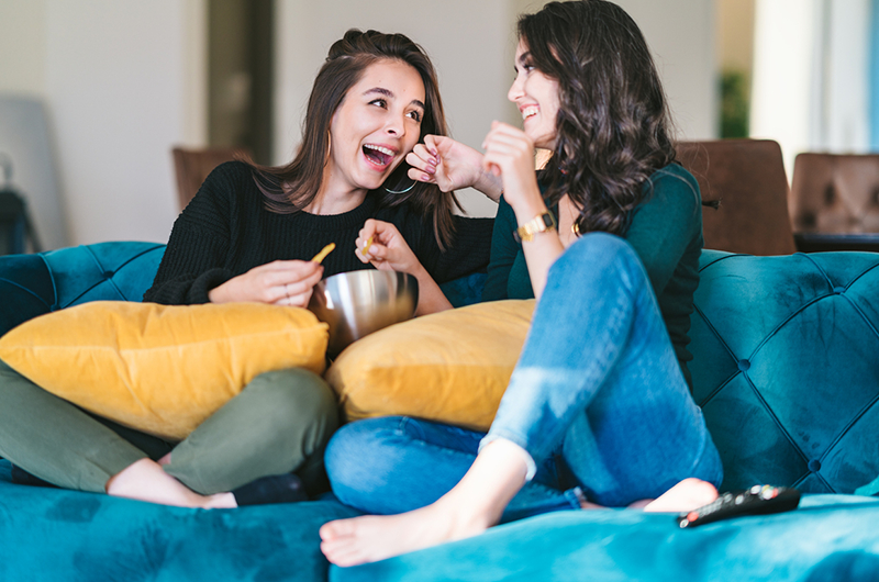 Two women sitting together on a couch