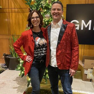 Couple poses in front of a Christmas tree